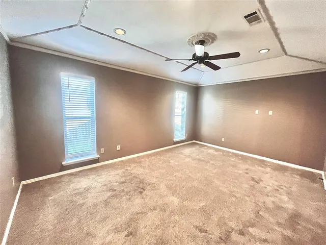 en empty room with windows and fan