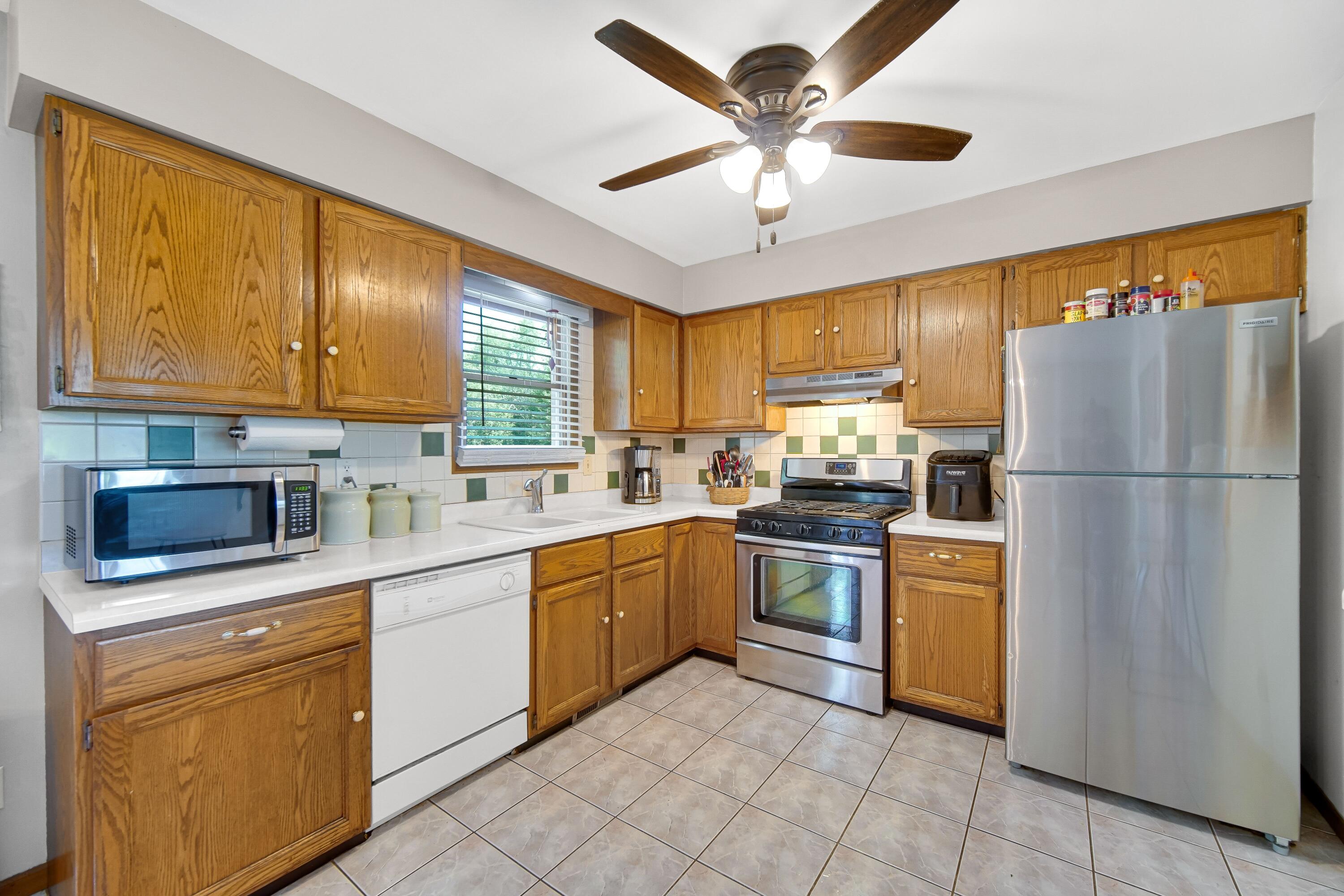 4000 Willowood Court Crown Point, IN 46307 - Photo 7 of 20 a kitchen with cabinets stainless steel appliances and a window