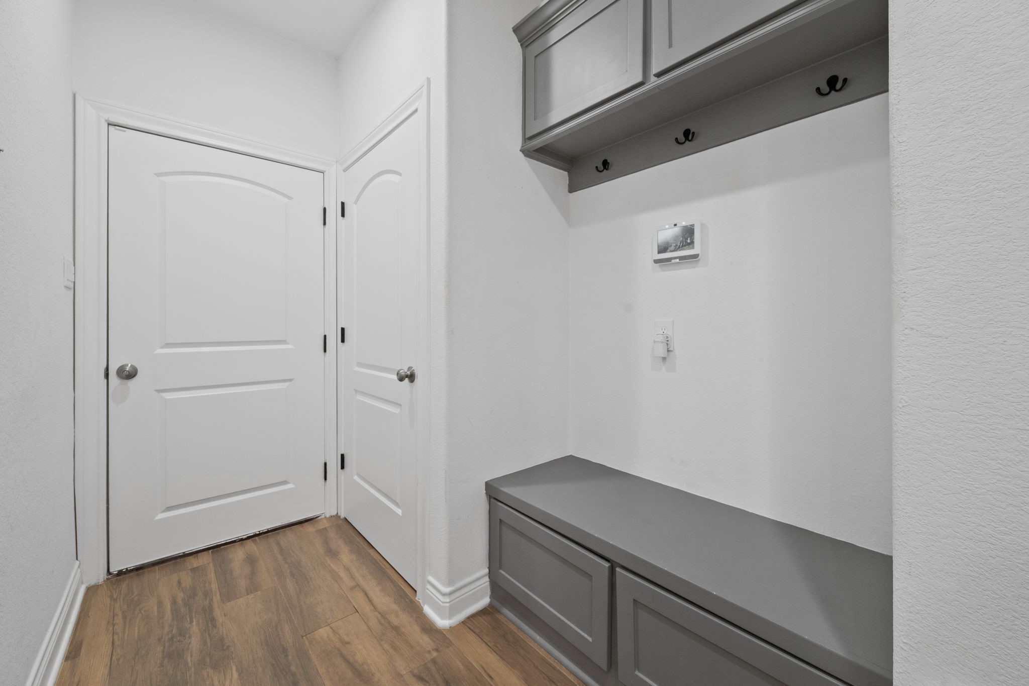 7815 Timber Switch Road Cleveland, TX 77328 - Photo 24 of 39 Charming entryway featuring elegant wood flooring and a practical built-in bench with overhead storage, perfect for organizing essentials.