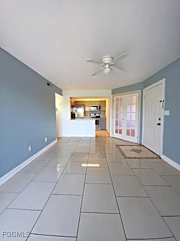 a big room with chandelier fan and windows