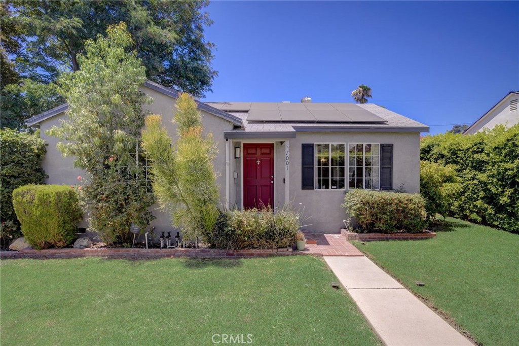 7001 Lindley Avenue Reseda, CA 91335 - Photo 1 of 45 a front view of a house with a garden and yard