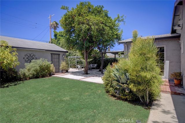 a front view of a house with a garden and plants