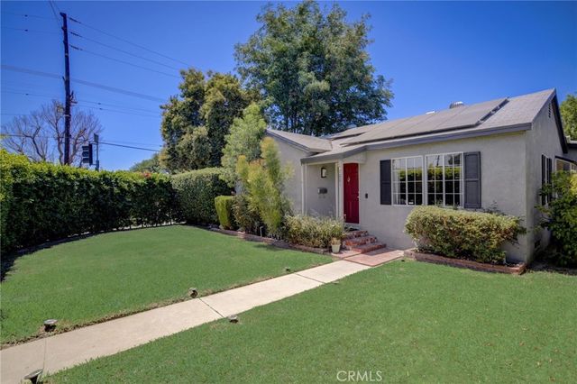 a view of a house with a yard and potted plants