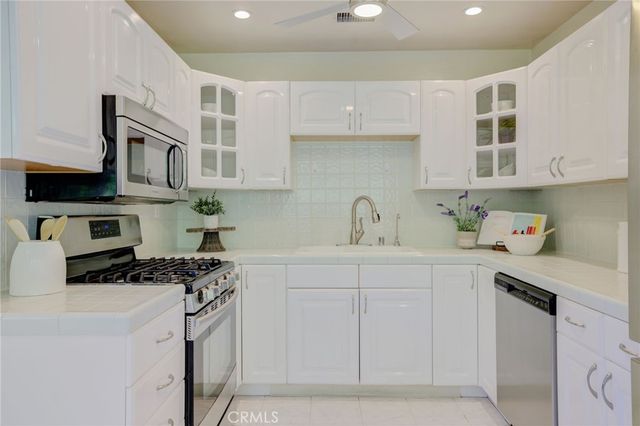 a kitchen with stainless steel appliances a sink a stove and cabinets