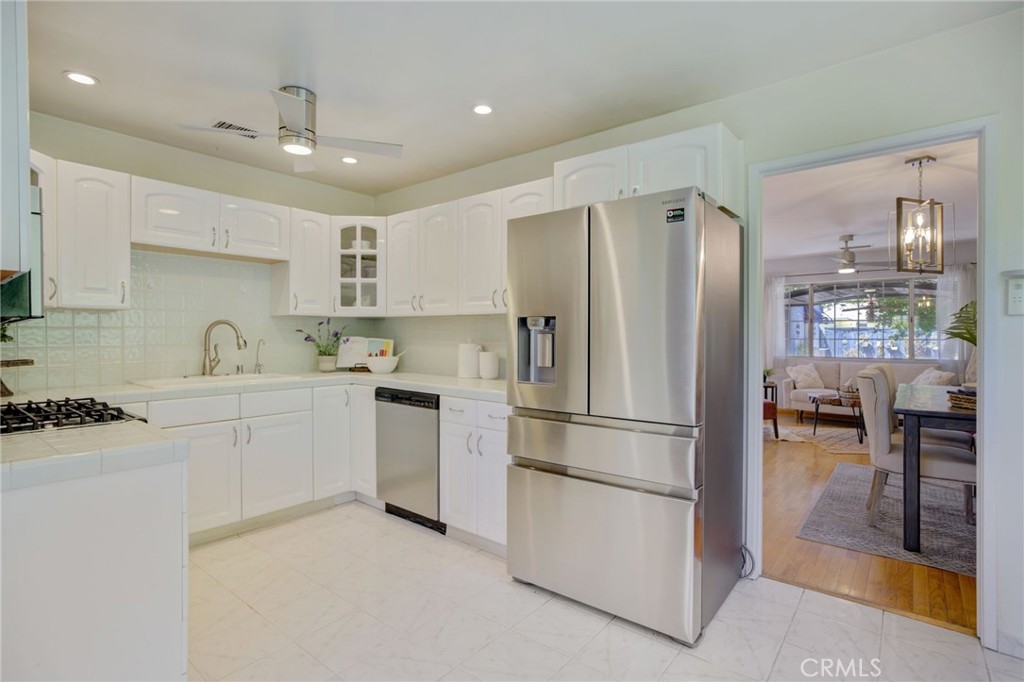 7001 Lindley Avenue Reseda, CA 91335 - Photo 7 of 45 a kitchen with a refrigerator a sink and a stove top oven