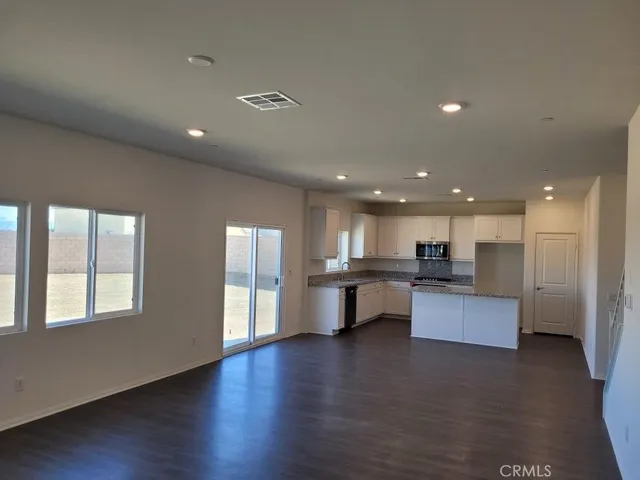 a view of kitchen with kitchen island refrigerator wooden floor and window