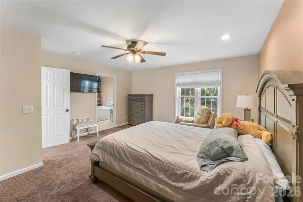 a bedroom with a large bed and a chandelier
