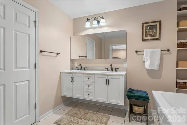 a spacious bathroom with a mirror and a sink