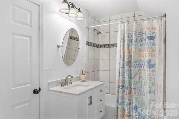a bathroom with a granite countertop sink a mirror and shower