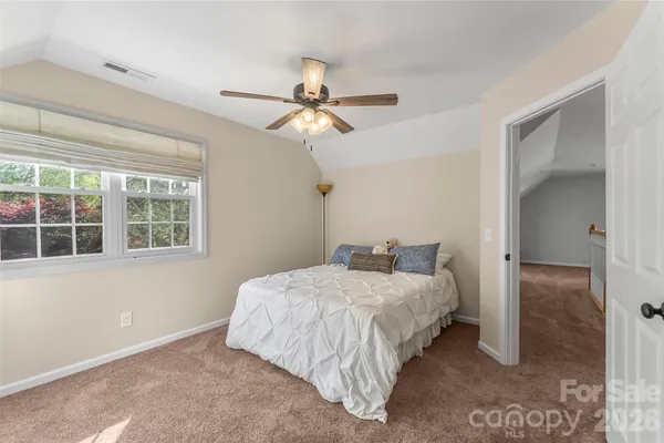 a bedroom with a bed ceiling fan and a window