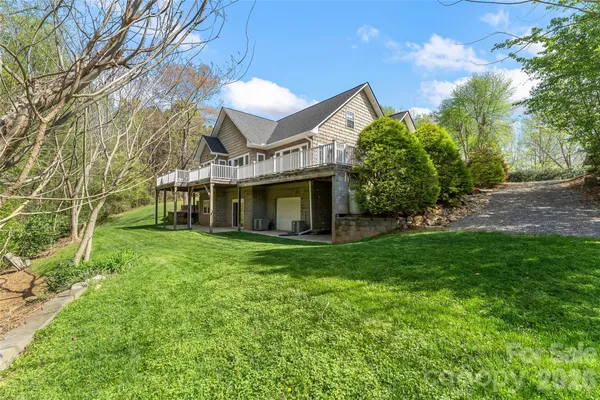 a view of a big house with a big yard and large tree