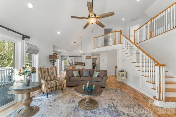 a living room with furniture and a dining table with wooden floor