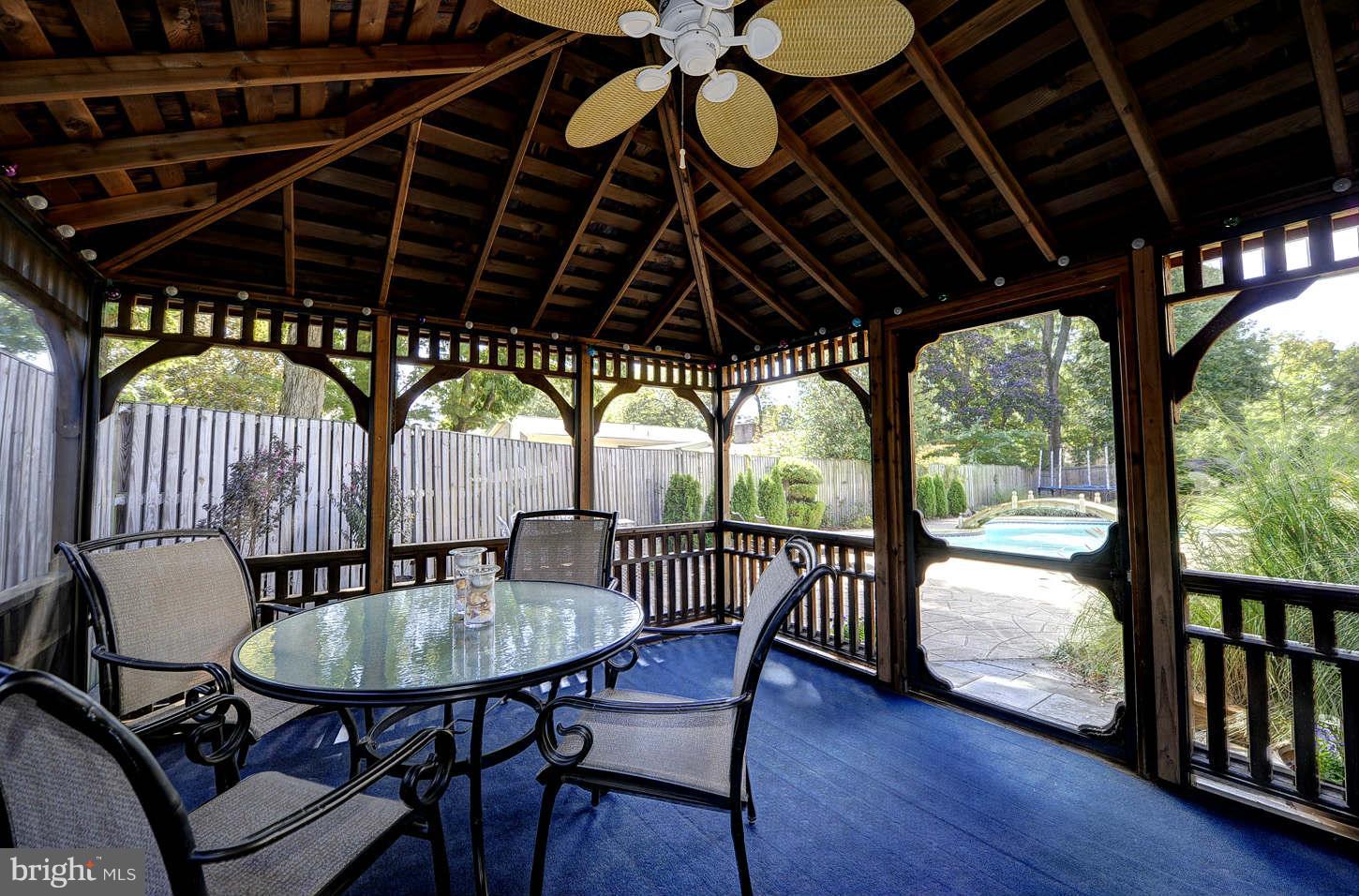 10009 Hall Road Potomac, MD 20854 - Photo 9 of 10 a porch with table and chairs with wooden floor