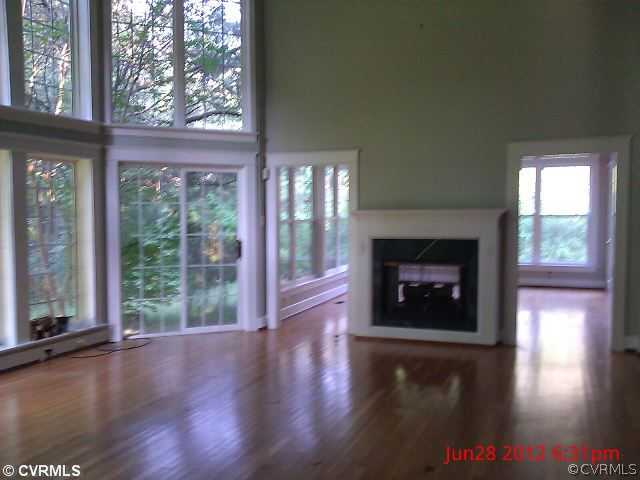 4212 Whitehall Road Sandy Hook, VA 23153 - Photo 3 of 9 a view of an empty room with wooden floor and a fireplace