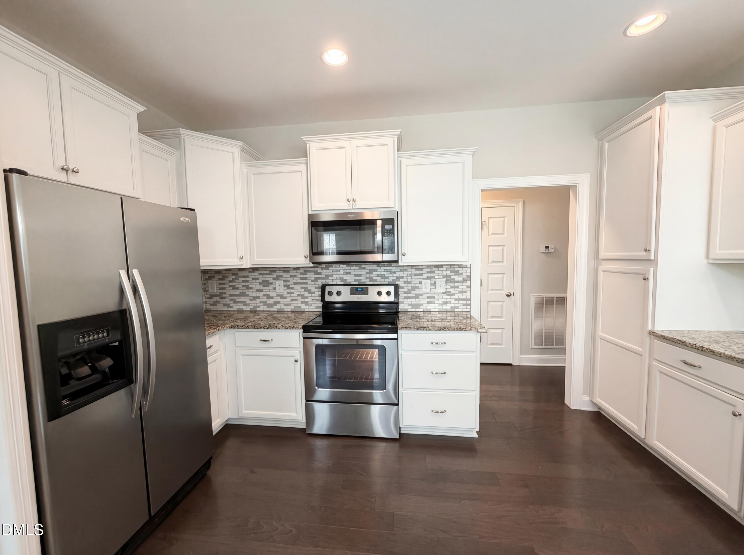 987 Red Stone Court Rougemont, NC 27572 - Photo 4 of 14 a kitchen with stainless steel appliances a refrigerator a stove and white cabinets
