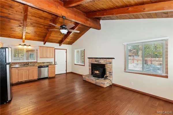 a kitchen with stainless steel appliances wooden floor and a fireplace