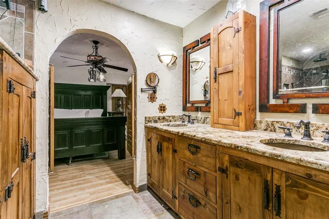 a bathroom with a granite countertop sink a large mirror and a shower