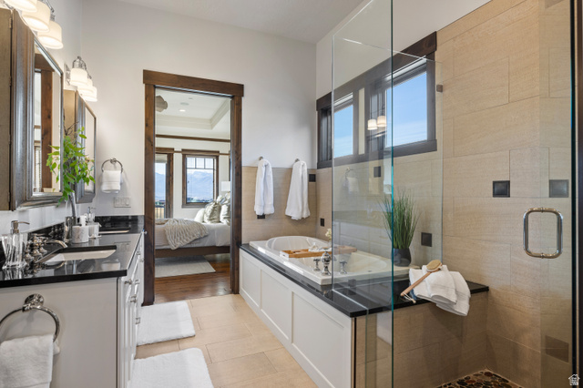 707 Chimney Rock Road, Unit 247 Heber City, UT 84032 - Photo 16 of 64 Ensuite bathroom featuring a shower stall, double vanity, a garden tub, light tile patterned floors, and a tray ceiling