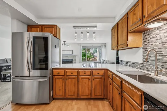 a kitchen with stainless steel appliances granite countertop a refrigerator a sink a stove and a microwave