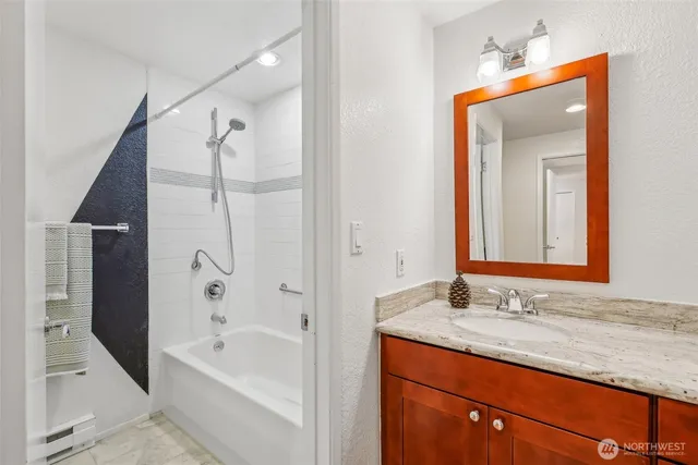 a bathroom with a granite countertop sink mirror and a bath tub
