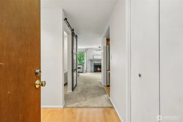 a view of a hallway with wooden floor and a living room