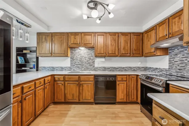 a kitchen with stainless steel appliances granite countertop a stove sink and cabinets