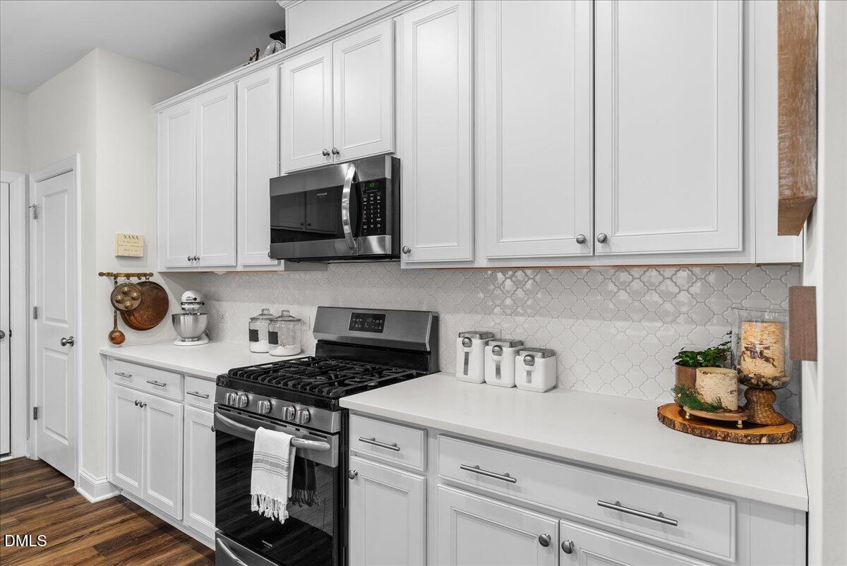 100 Masden Road Holly Springs, NC 27540 - Photo 8 of 39 a kitchen with stainless steel appliances white cabinets and a stove top oven