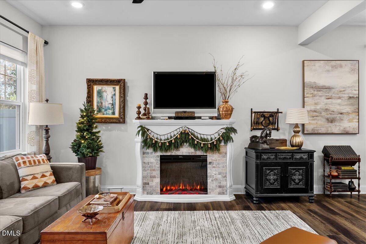 100 Masden Road Holly Springs, NC 27540 - Photo 12 of 39 a living room with furniture a flat screen tv and a fireplace