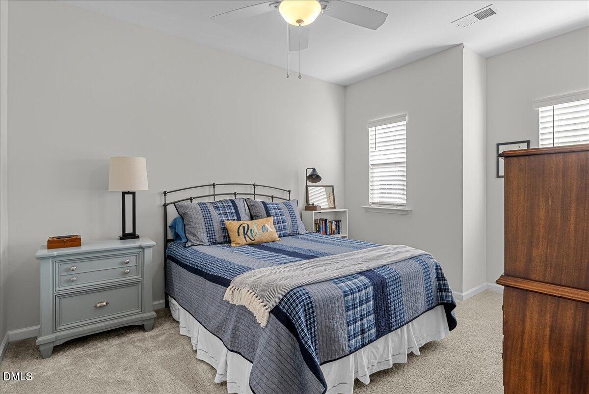 100 Masden Road Holly Springs, NC 27540 - Photo 23 of 39 a bedroom with a bed and a chandelier