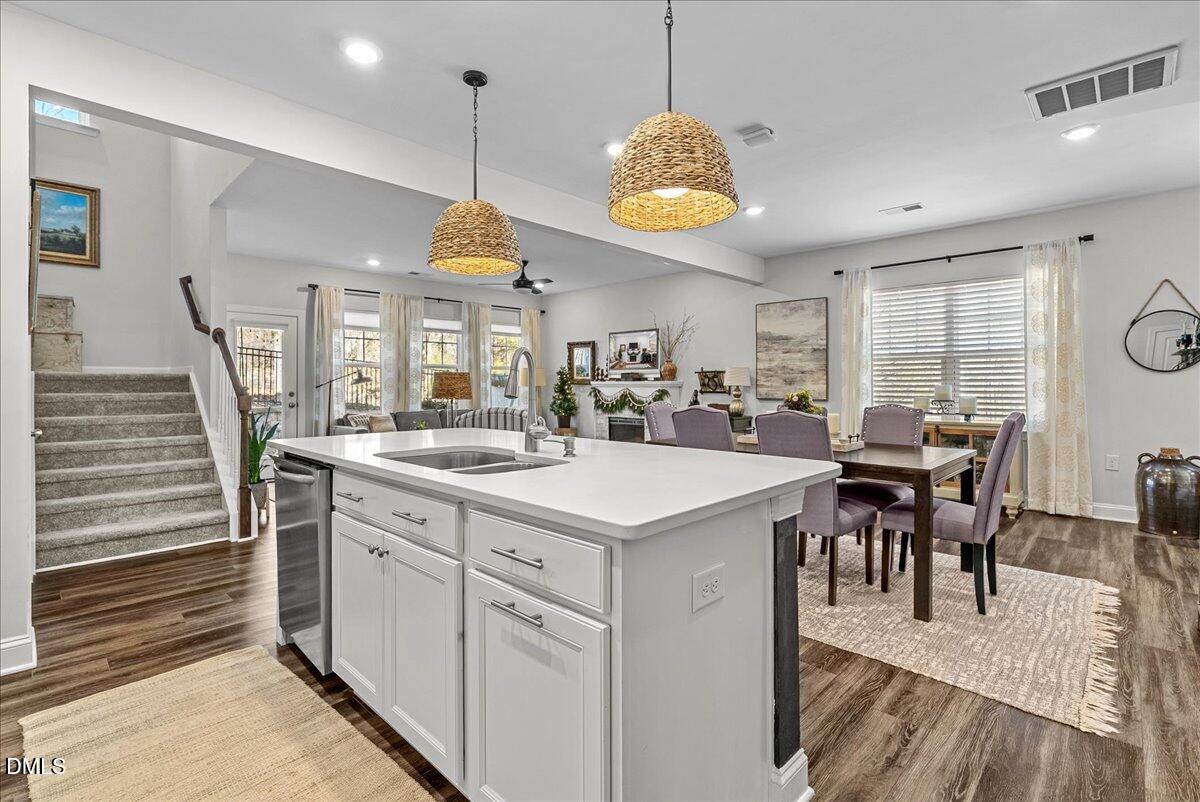 100 Masden Road Holly Springs, NC 27540 - Photo 4 of 39 a view of a dining room and livingroom with furniture wooden floor a rug a painting and a chandelier