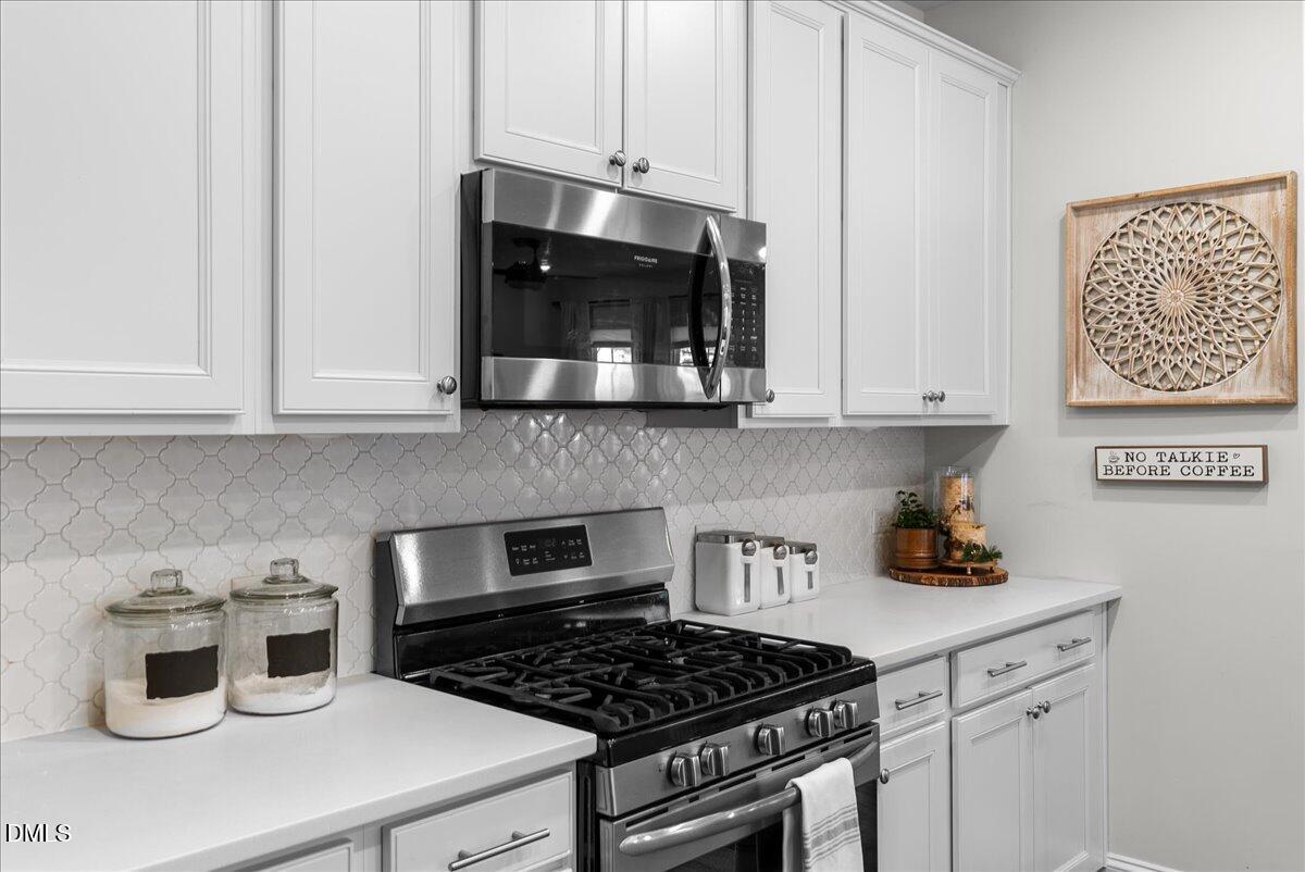 100 Masden Road Holly Springs, NC 27540 - Photo 7 of 39 a kitchen with white cabinets a sink and white appliances