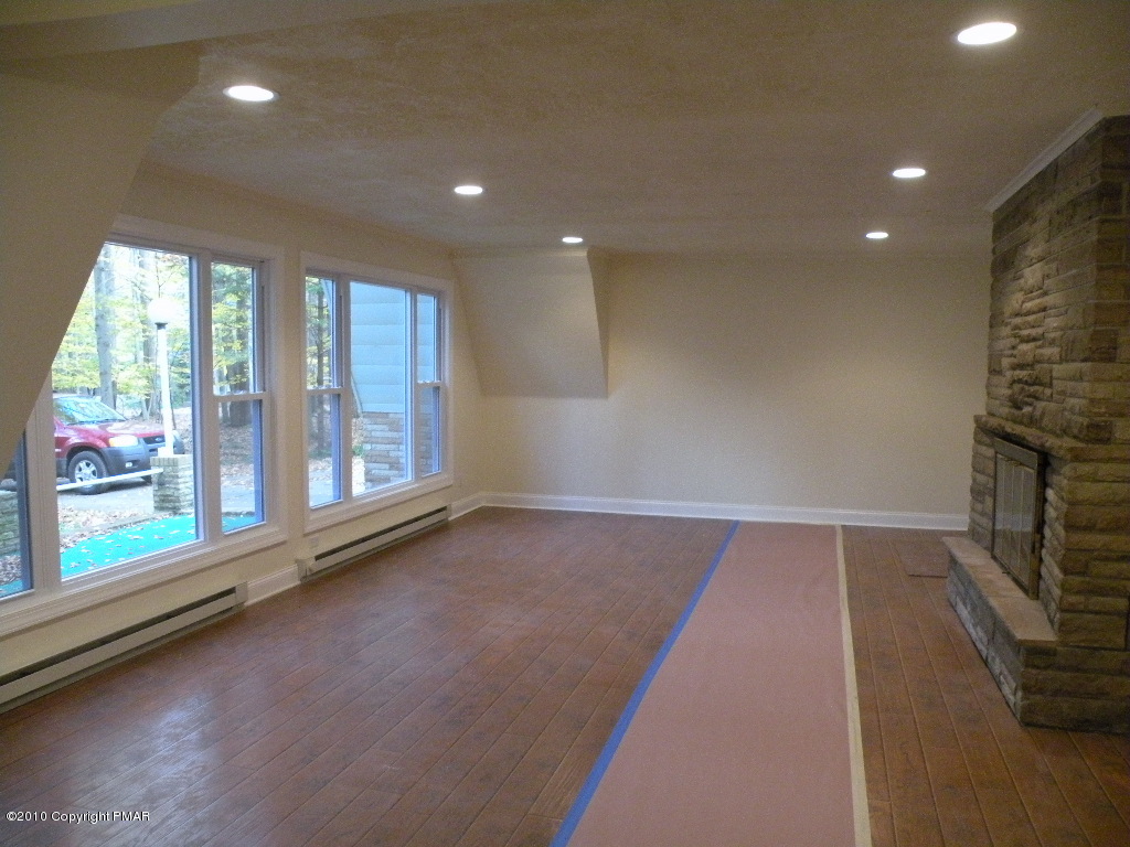 715 Deer Run Road Pocono Lake, PA 18347 - Photo 3 of 20 an empty room with wooden floor and windows