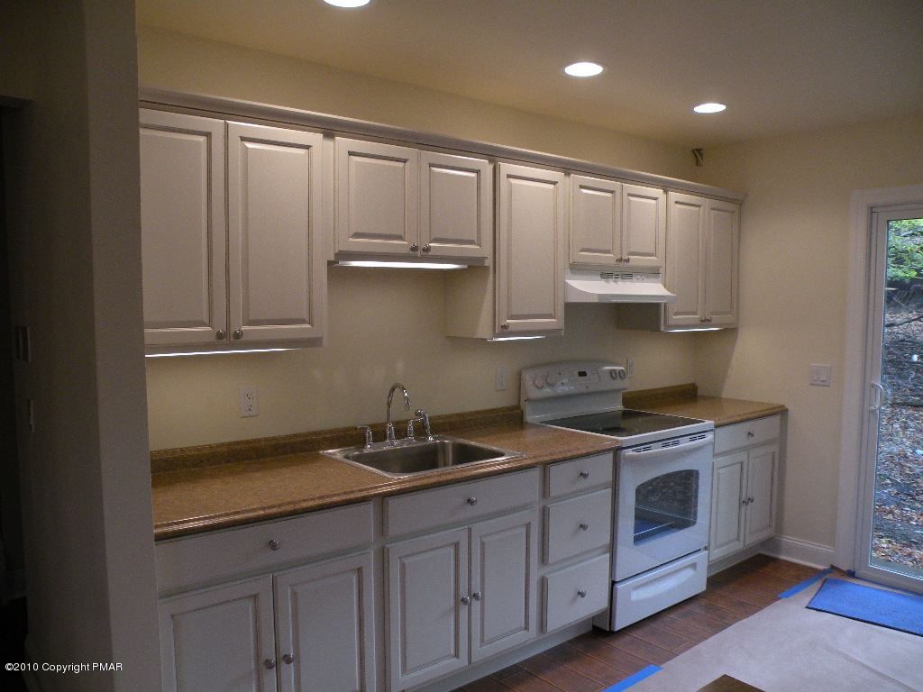 715 Deer Run Road Pocono Lake, PA 18347 - Photo 6 of 20 a kitchen with stainless steel appliances granite countertop a sink and cabinets with wooden floor