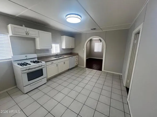 a kitchen with granite countertop a stove top oven sink and cabinets