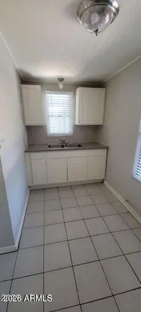 a kitchen with a sink a stove cabinets and a window