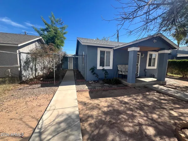 a front view of a house with a yard and potted plants
