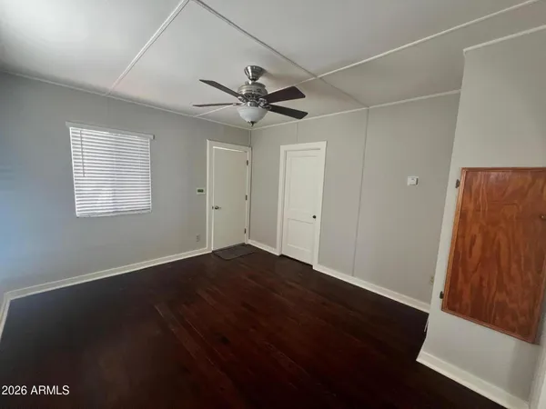 a view of an empty room with a window and wooden floor
