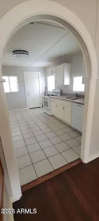 a large white kitchen with a sink and dishwasher a stove with wooden floor