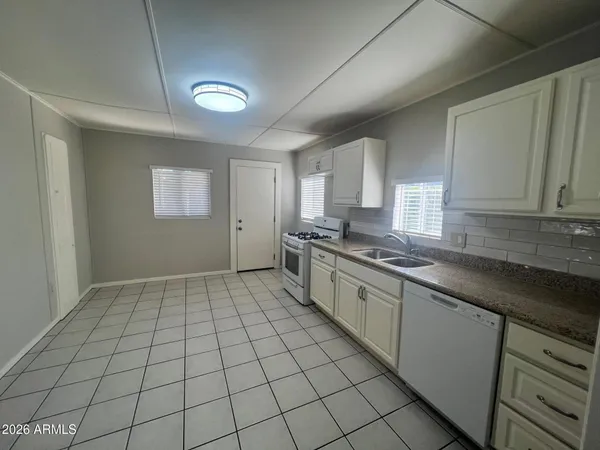 a large kitchen with a stove a sink dishwasher and a refrigerator
