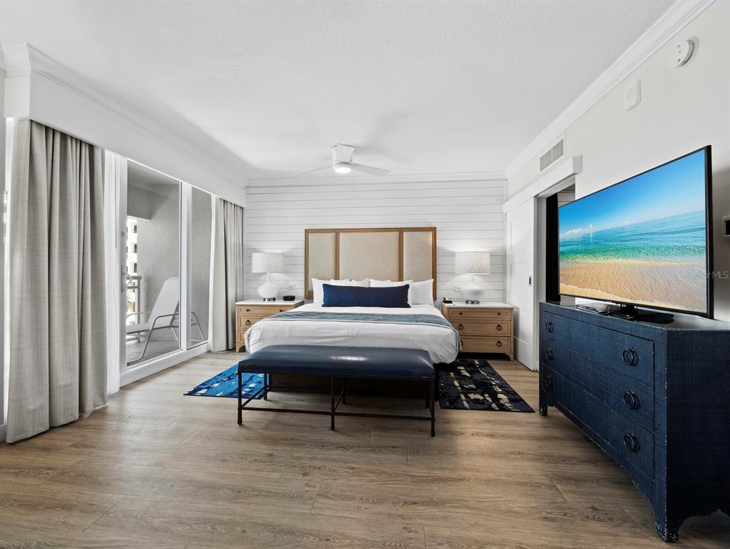 210 Sands Point Road, Unit 2405 Longboat Key, FL 34228 - Photo 14 of 36 a bedroom with furniture and a flat screen tv