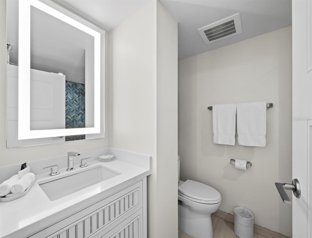 210 Sands Point Road, Unit 2405 Longboat Key, FL 34228 - Photo 18 of 36 a bathroom with a toilet sink and mirror