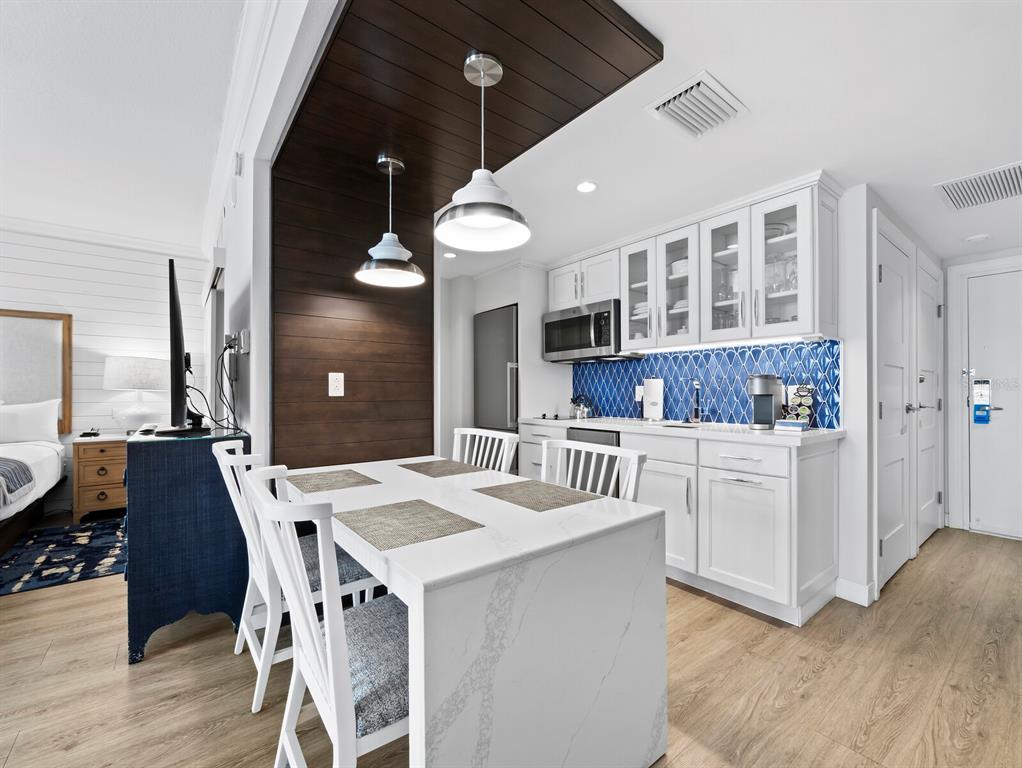 210 Sands Point Road, Unit 2405 Longboat Key, FL 34228 - Photo 7 of 36 a dinning area with white cabinets and chandelier