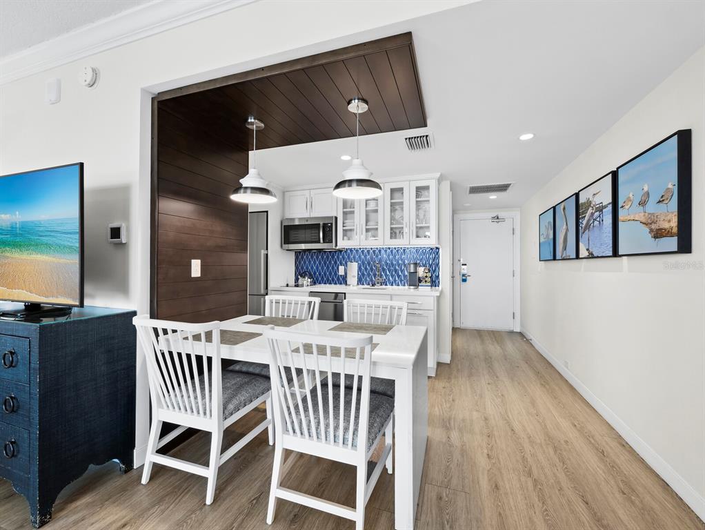210 Sands Point Road, Unit 2405 Longboat Key, FL 34228 - Photo 8 of 36 a view of a dining room with furniture and wooden floor
