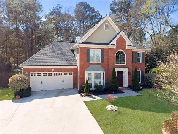 a front view of a house with a garden and plants