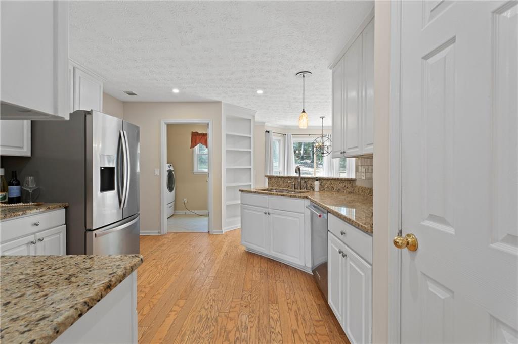 1381 Gateswalk Path Lawrenceville, GA 30045 - Photo 11 of 45 a kitchen with refrigerator cabinets and wooden floor