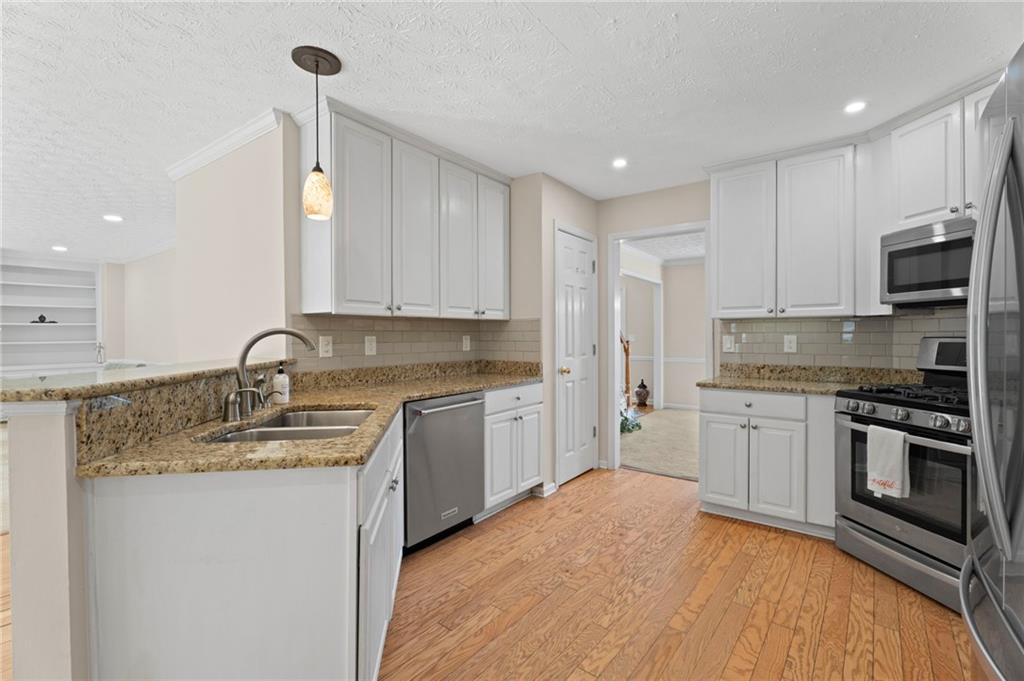 1381 Gateswalk Path Lawrenceville, GA 30045 - Photo 12 of 45 a kitchen with stainless steel appliances granite countertop a sink stove and refrigerator