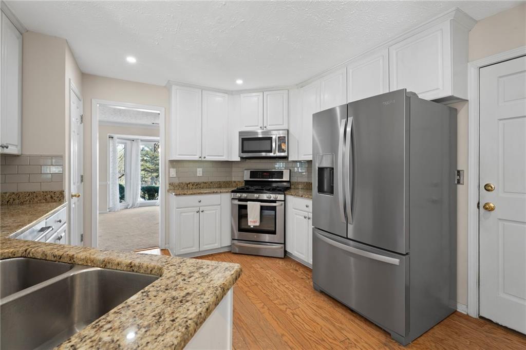 1381 Gateswalk Path Lawrenceville, GA 30045 - Photo 13 of 45 a kitchen with granite countertop a refrigerator and a sink