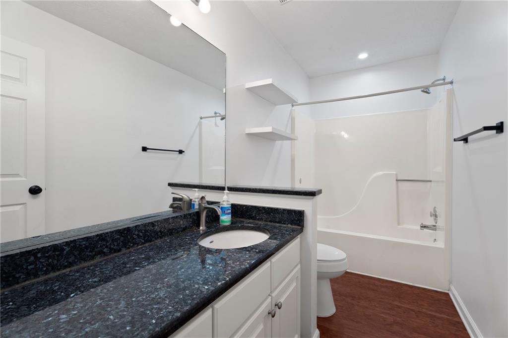 1381 Gateswalk Path Lawrenceville, GA 30045 - Photo 30 of 45 a bathroom with a granite countertop sink a mirror and shower
