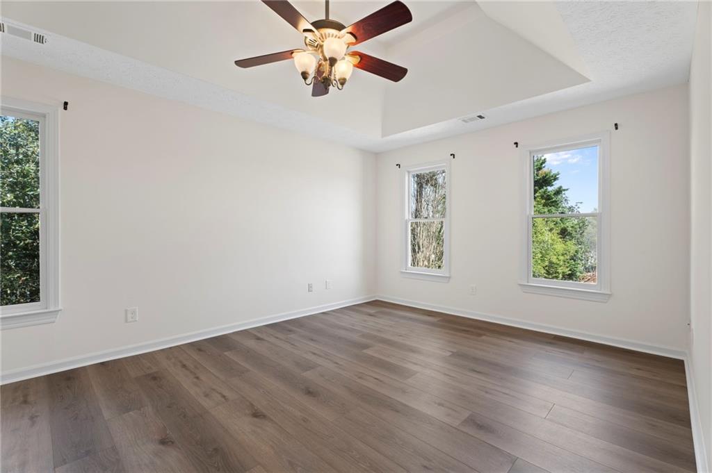 1381 Gateswalk Path Lawrenceville, GA 30045 - Photo 32 of 45 an empty room with wooden floor chandelier fan and windows
