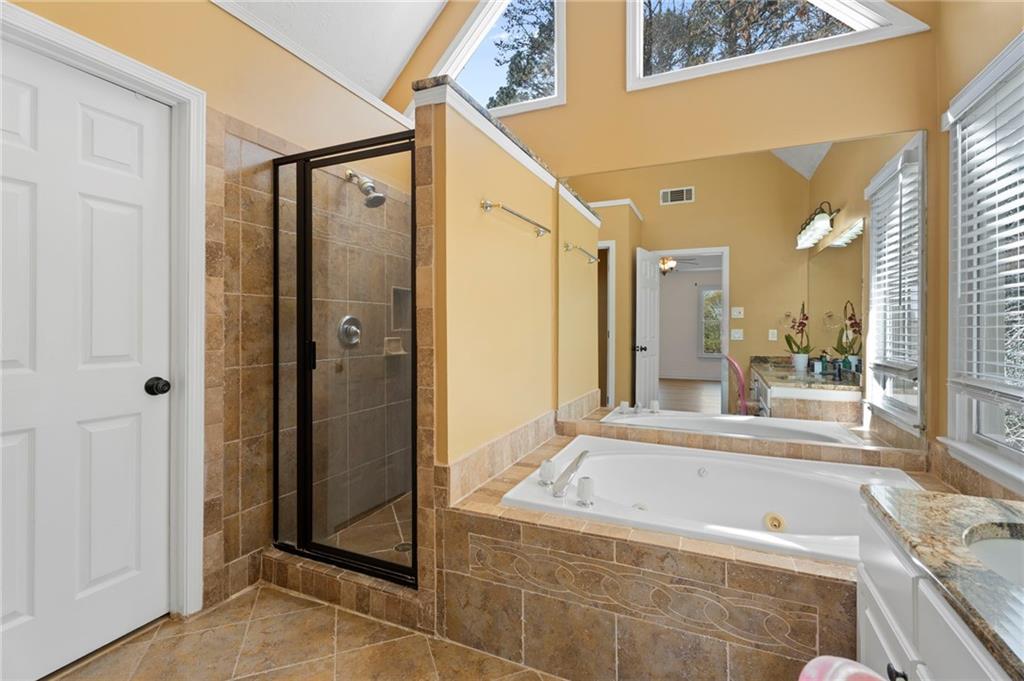 1381 Gateswalk Path Lawrenceville, GA 30045 - Photo 35 of 45 a bathroom with a granite countertop tub shower and mirror